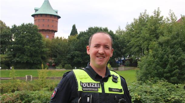Härte und Menschlichkeit: Wie der Cuxhavener Polizist Jan Abbes mit Attacken umgeht Polizeikommissar Jan Abbes vor dem Cuxhavener Wasserturm – ein Mann, der hinter der Uniform Mensch bleibt.