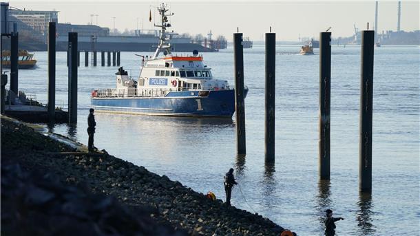 Zehnjähriger fällt in Hamburg in Elbe Polizeitaucher und Polizeibeamte bei der Suche nach dem Jungen in der Elbe.