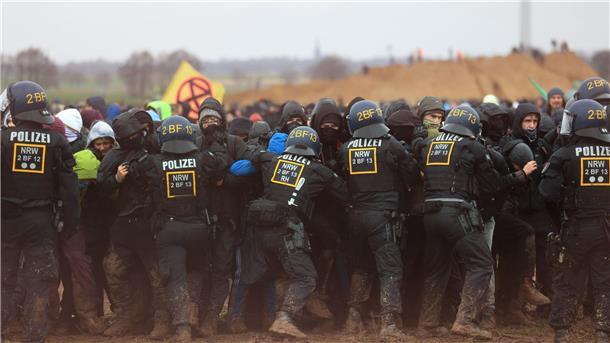 Polizisten drängen Demonstranten am Rande des Braunkohletagebaus bei Lützerath zurück. Die Polizei habe „hochprofessionell“ gearbeitet, so NRW-Innenminister Reul.