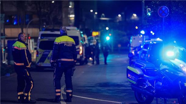 Polizisten sperren die Straße vor dem Tatort ab.