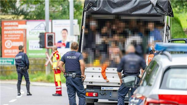 Polizisten stehen bei einer Kontrolle in Österreich an einem Kleintransporter. Die Beamten entdeckten dabei 53 Personen auf der Ladefläche.