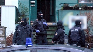 Polizisten stehen im Bremer Stadtteil Steintorviertel vor einem Gebäude. Ermittler von Landes- und Bundespolizei und Zoll durchsuchten am Morgen mehrere Häuser und Wohnungen.