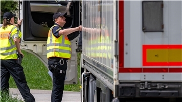 Polizisten überprüfen bei einer Verkehrskontrolle einen Lastwagen.
