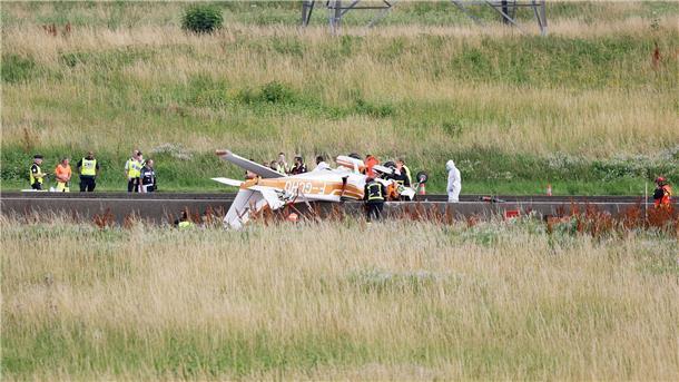 Tote bei Absturz von Sportflugzeug auf Autobahn bei Paris Polizisten und Rettungskräfte stehen an der Absturzstelle der Cessna bei Collégien.