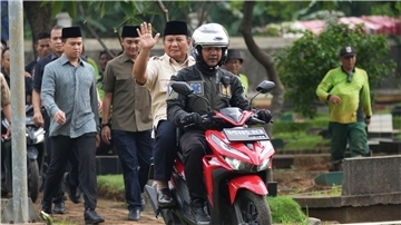 Prabowo Subianto wird von einem Polizisten zum Grab seines Vaters in Jakarta gefahren.