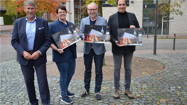 Präsentierten den Rotary-Adventskalender vor romantisch-herbstlicher Kulisse in Zeven: Clubpressesprecher Marco Tulodetzki (von links) sowie die Club-Mitglieder Ann-Katrin Franck, Arne Suter und Stefan Mahnken.