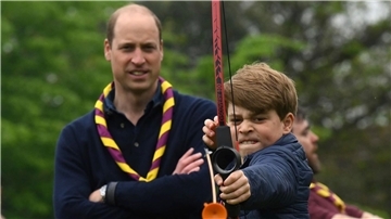 Prinz George versucht sich neben seinem Vater Prinz William im Bogenschießen.
