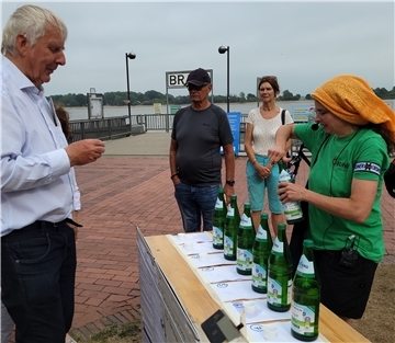 Probieren wirkt überzeugend in Sachen Versalzung: Annette Chapligin (rechts) vom Aktionsbündnis gegen die Weservertiefung schenkte Wasser mit unterschiedlichem Salzgehalt ein.