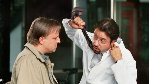 Prof. Karl-Friedrich Boerne (Jan Josef Liefers, r) macht es anschaulich: Er erklärt Hauptkommissar Frank Thiel (Axel Prahl) einen möglichen Tathergang - eine Szene aus „Tatort: Der dunkle Fleck“.