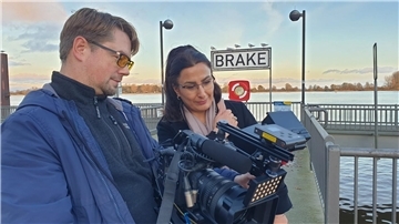 Eine Frau und ein Mann begutachten in einer Filmkamera eine Aufnahme