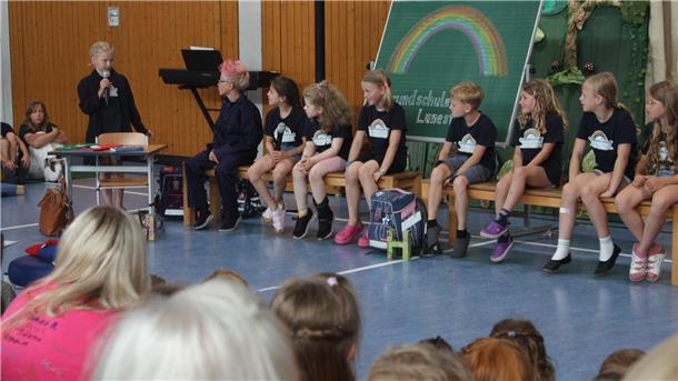 Viertklässler verabschiedet: Lunestedter Schulfest voller Highlights Kinder sitzen auf Bänken