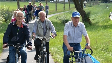 Eine Gruppe von Radfahrern fährt auf einem schmalen Weg.