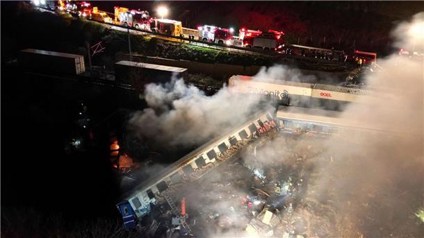 Viele Tote nach Zug-Zusammenstoß in Griechenland Rauch steigt auf, während Feuerwehrleute und Rettungskräfte nach dem Zusammenstoß der beiden Züge nahe Larissa im Einsatz sind.