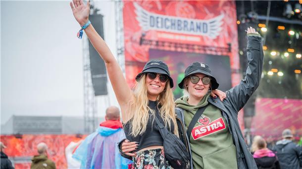 Deichbrand 2023 ertrinkt: REGEN und SCHLAMM ohne Ende (Fotos) Regenwetter am Samstagnachmittag auf dem Infield schmälert die Festivallaune bei Stefanie und Kim nicht.