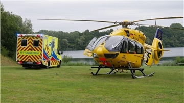 Ein Krankenwagen steht am Kreidesee. Neben ihm steht ein Rettungshubschrauber. 