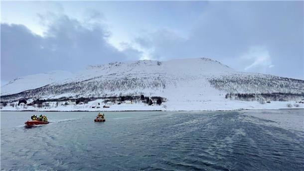 Vier Tote bei Lawinenabgängen in Norwegen Rettungshelfer suchen nach einer Schneelawine auf der Insel Reinøya mit Booten nach Überlebenden.