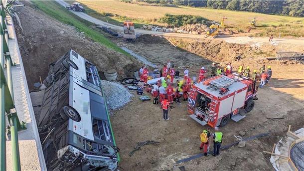 Bus stürzt in Österreich von Brücke - mehrere Verletzte Rettungskräfte arbeiten an der Unfallstelle.