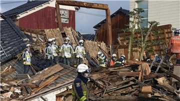 Rettungskräfte arbeiten an einem eingestürzten Gebäude in Wajima.