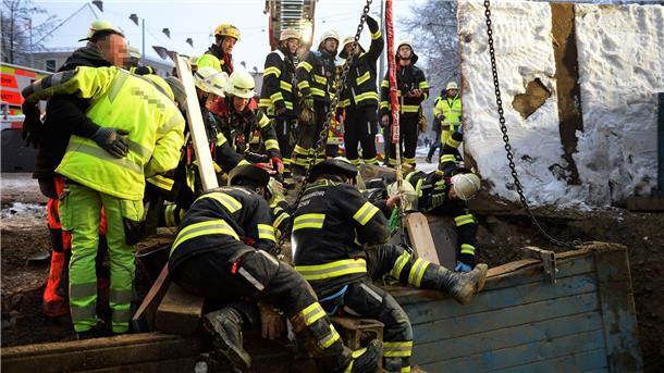München: Bauarbeiter verschüttet und schwer verletzt  Rettungskräfte der Feuerwehr sind am Unfallort im Einsatz.