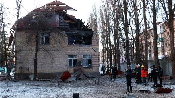 Krieg gegen die Ukraine: So ist die Lage Rettungskräfte stehen neben einem beschädigten Gebäude in Kiew.