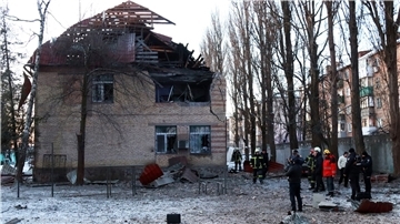 Rettungskräfte stehen neben einem beschädigten Gebäude in Kiew.
