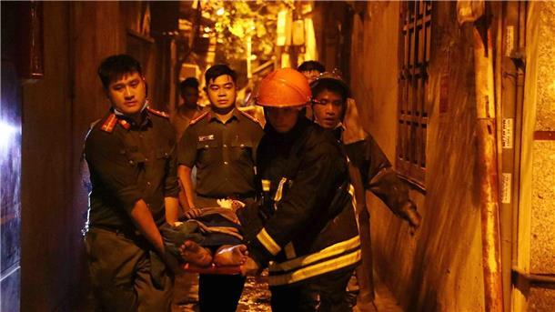 Großbrand in Wohnhaus in Hanoi: Zahlreiche Opfer befürchtet Rettungskräfte tragen eine Person aus einem brennenden Gebäude in der vietnamesischen Hauptstadt Hanoi.
