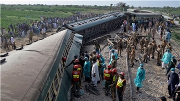 Rettungskräfte und Soldaten versuchen nach einem Zugunglück in Pakistan Menschen aus dem entgleisten Zug zu retten.
