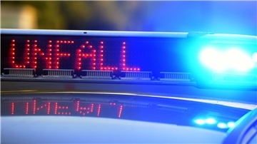 Auf einem Polizeifahrzeug warnt eine Leuchtschrift vor einer Unfallstelle.