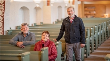 Roland Hoffmann (von links), Karin Littmann und Jan-Christoph Blanken in der St. Marien-Kirche in Loxstedt. Zwei Männer, die eine Frau in ihre Mitte nehmen, an den Bänken der Kirche.  Hoffmann und Littmann sitzen, Blanken steht.