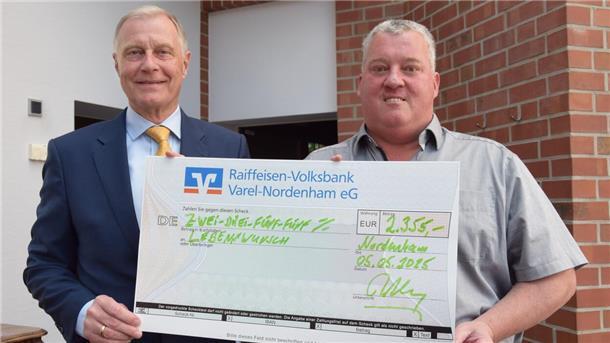 Wieso Rolf Ahlers aus Nordenham sein Geburtstagsgeld spendet Zwei Männer stehen nebeneinander und halten einen großen Scheck in die Kamera.