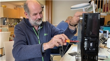 Ein Mann schraubt an einem alten Kassettendecks, Rolf Wilkens im Reparatur-Café des Mehrgenerationenhauses in Nordenham.