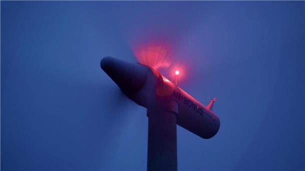 Windkraftrad mit rotierenden Flügeln und blinkenden Lichtern