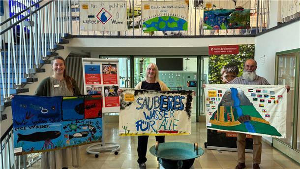 Rund 100 Kinder und Jugendliche haben unter dem Motto „Sauberes Wasser für alle“ auf Initiative des Kinderhilfswerk terre des hommes farbenfrohe Banner gestaltet. Maja Tönjes vom Museum Kaskade (links) zeigt mit Regina und Daniel Hewer von der Ortsgruppe Delmenhorst-Ganderkesee Ausstellungsstücke, die im ältesten Speicherpumpwerk des OOWV zu sehen sind.
