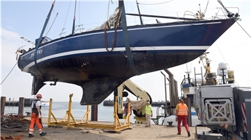Ein Schiff hängt an Seilen in der Luft.