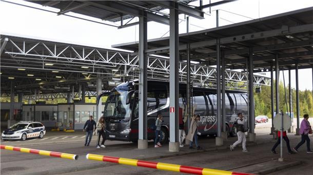 Russische Passagiere verlassen einen Bus und gehen zur Passkontrolle am Grenzübergang Vaalimaa zwischen Finnland und Russland.