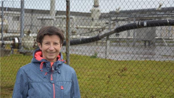 BUND Rotenburg: CCS-Pläne als teure Müllentsorgung? Eine Frau steht vor einem Maschendrahtzaun, der eine Gasförderstation einzäunt.