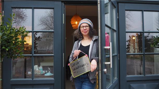 Frau steht in einer Tür mit einem Schild in der Hanbfdn