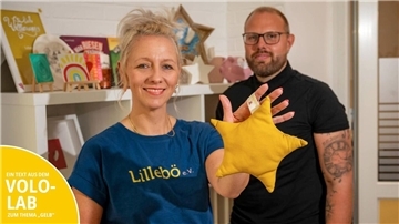Sabrina Kuiper (li.) und Roman W. (re.) zeigen ein sternenförmiges Kissen, das bei einem der Näh-Events des Vereins Lillebö entstanden ist.