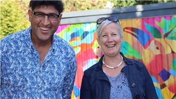 Said Tiraei aus Oldenburg mit Hausbesitzerin Regina Gross vor dem Bild Nr.11: „Bunte Papageien“ .