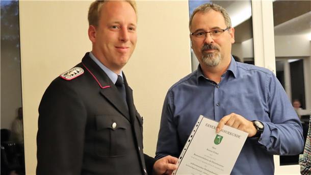 Samtgemeindbürgermeister Oliver Moje (rechts) überreicht Bastian Finke, stellvertretender Ortsbrandmeister der Ortsfeuerwehr Westertimke, die Ernennungsurkunde.