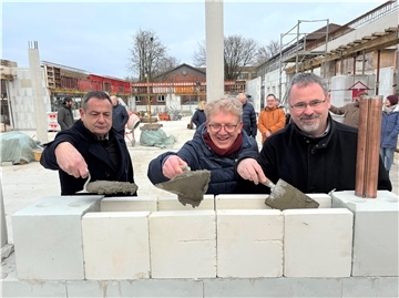 Samtgemeindebürgermeister Oliver Moje, Schulleiter Tim Weidenfeld und Architekt Martin Menzel (von rechts) packen an: Mit einer verspäteten Grundsteinlegung wird das Zukunftsprojekt Mensabau in Tarmstedt gefeiert.