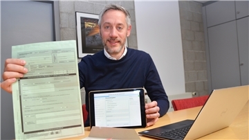 Sascha Glaß zeigt im Vergleich den Totenschein in Papierform und digital auf dem iPad.