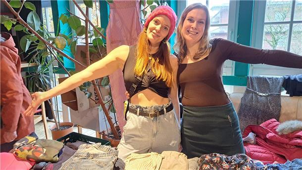 Bild von zwei jungen Frauen, die ihre Flohmarktwaren präsentieren