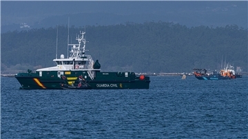 Schiffe der Guardia Civil und des Zolls beteiligen sich an der Bergung eines mutmaßlichen Drogen-U-Boots, von dem nur eine Spitze aus dem Wasser ragt.