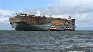 Schlepper begleiten den schwer beschädigten Autofrachter “Fremantle Highway„ in den Hafen.