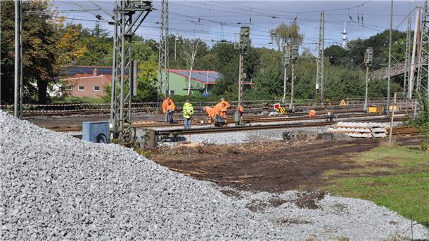 Schotterberge für die Schotterung der neuen Gleise türmen sich am Rande der Bahnstrecke.