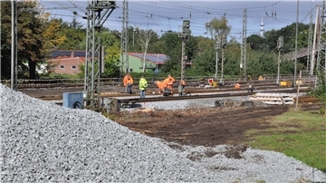 Schotterberge für die Schotterung der neuen Gleise türmen sich am Rande der Bahnstrecke.