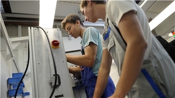 Schüler der Kooperativen Gesamtschule (KGS) aus den 9. und 10. Klassen der Realschule installieren in einem Klassenraum für Mechatronik Kabel an einer Schalteinheit.