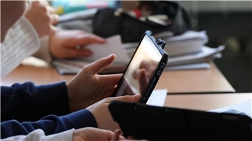 Schüler einer Grundschule in Berlin lösen im Unterricht an Tablets eine Aufgabe.