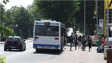 Schülerinnen und Schüler der Geschwister-Scholl-Schule steigen in der Hauptstraße in Altenwalde aus einem Bus.